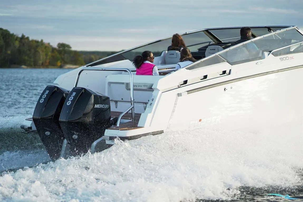 A white Flipper 900 DC boat with dual Mercury 300 engines speeds across a lake, carrying three passengers enjoying the ride.